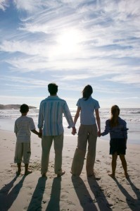 Young Couple with Two Children (8-12) Walking on the Beach